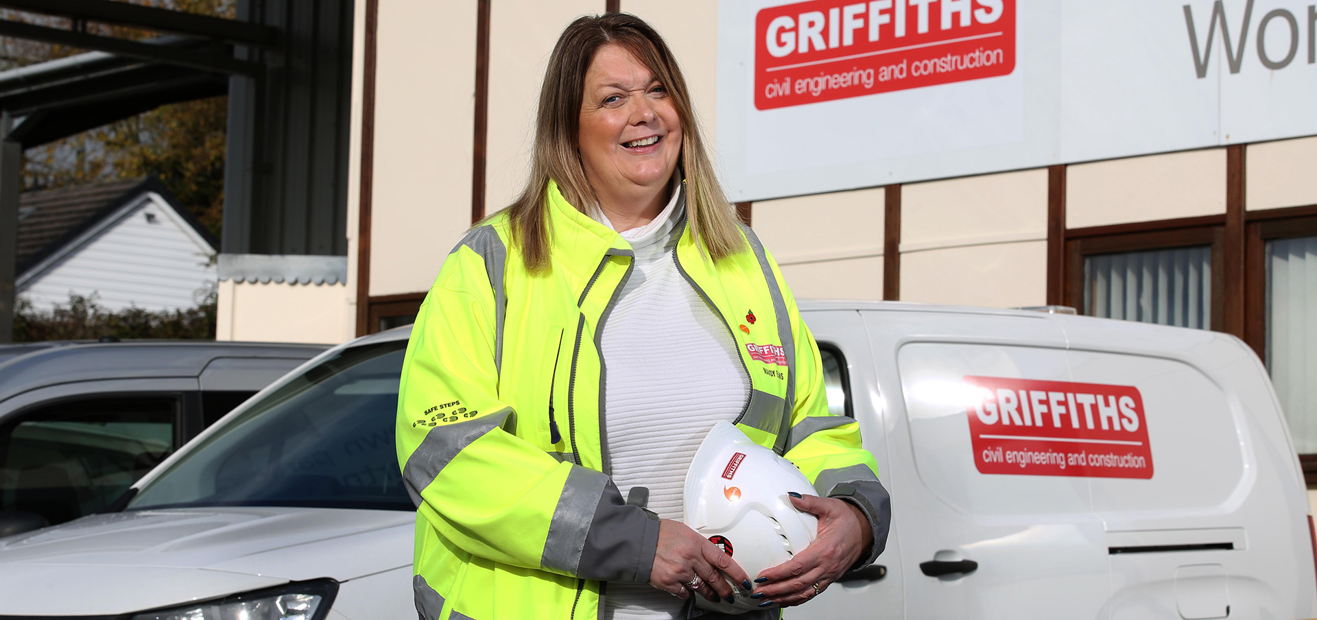Gweithiwr Griffiths yn sefyll o flaen fan waith